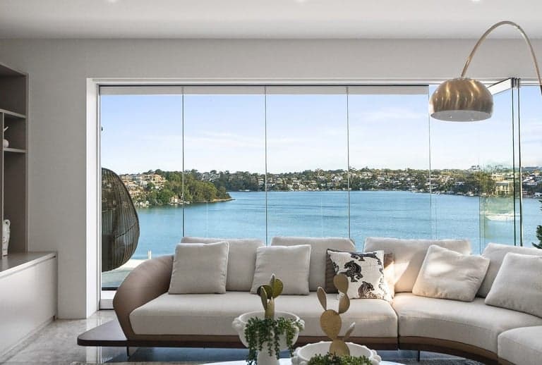 Full-height Sydney harbour windows dressed for privacy in a luxury living room