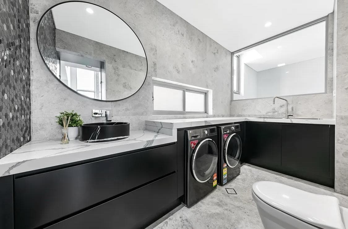 Sydney laundry renovation with black cabinets and stone bench