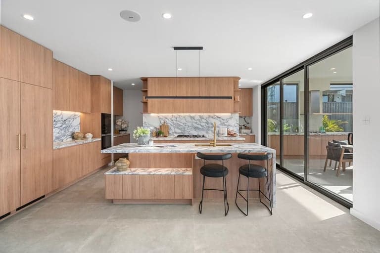Bespoke oak kitchen joinery with a marble island and black bar stools in Sydney