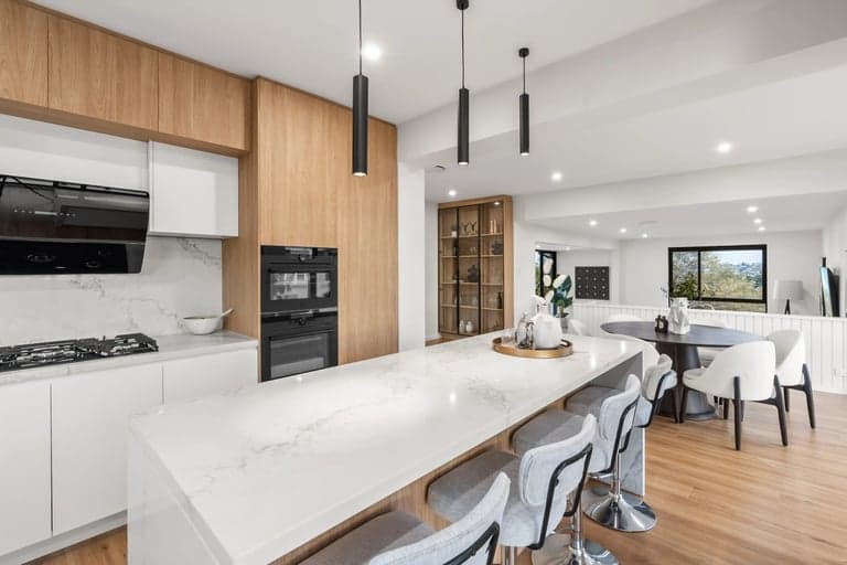 Oak and white kitchen island with pendant lights opening to a Sydney dining nook