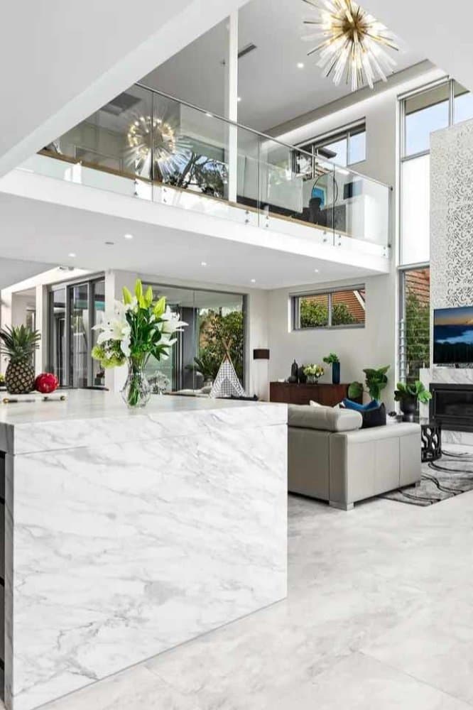 Marble kitchen island looking through to a double-height Sydney living room