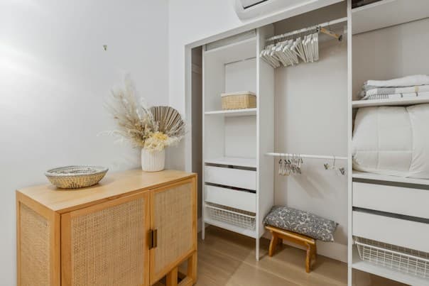 Open white built-in wardrobe in Sydney with hanging rail, shelves and cane storage