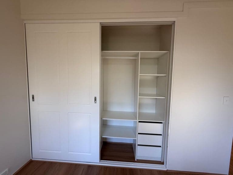 White sliding wardrobe interior in Sydney with hanging rails, shelves and drawers