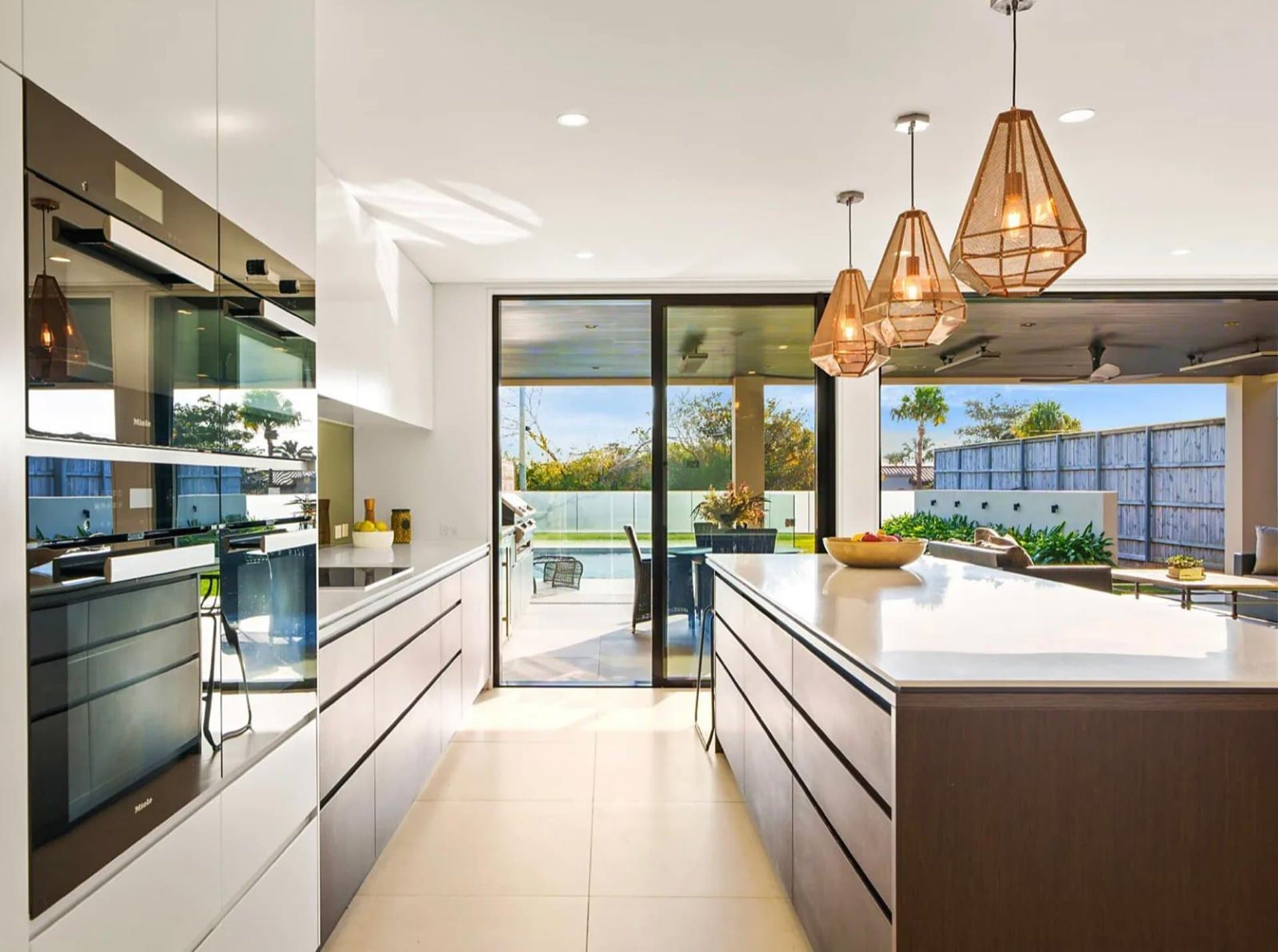 Handleless kitchen island facing glass doors to a Sydney backyard