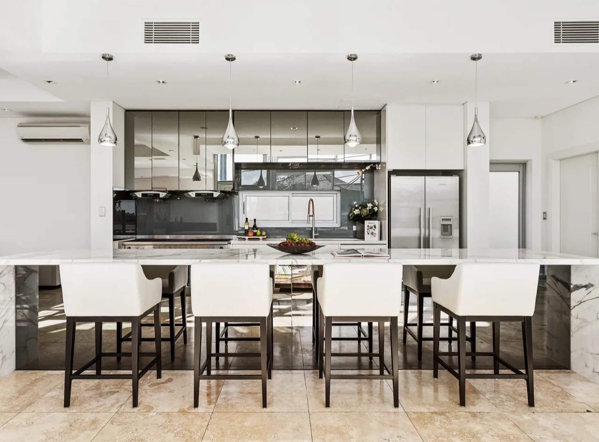 Marble kitchen bar renovation in Sydney with white stools and high-gloss cabinets