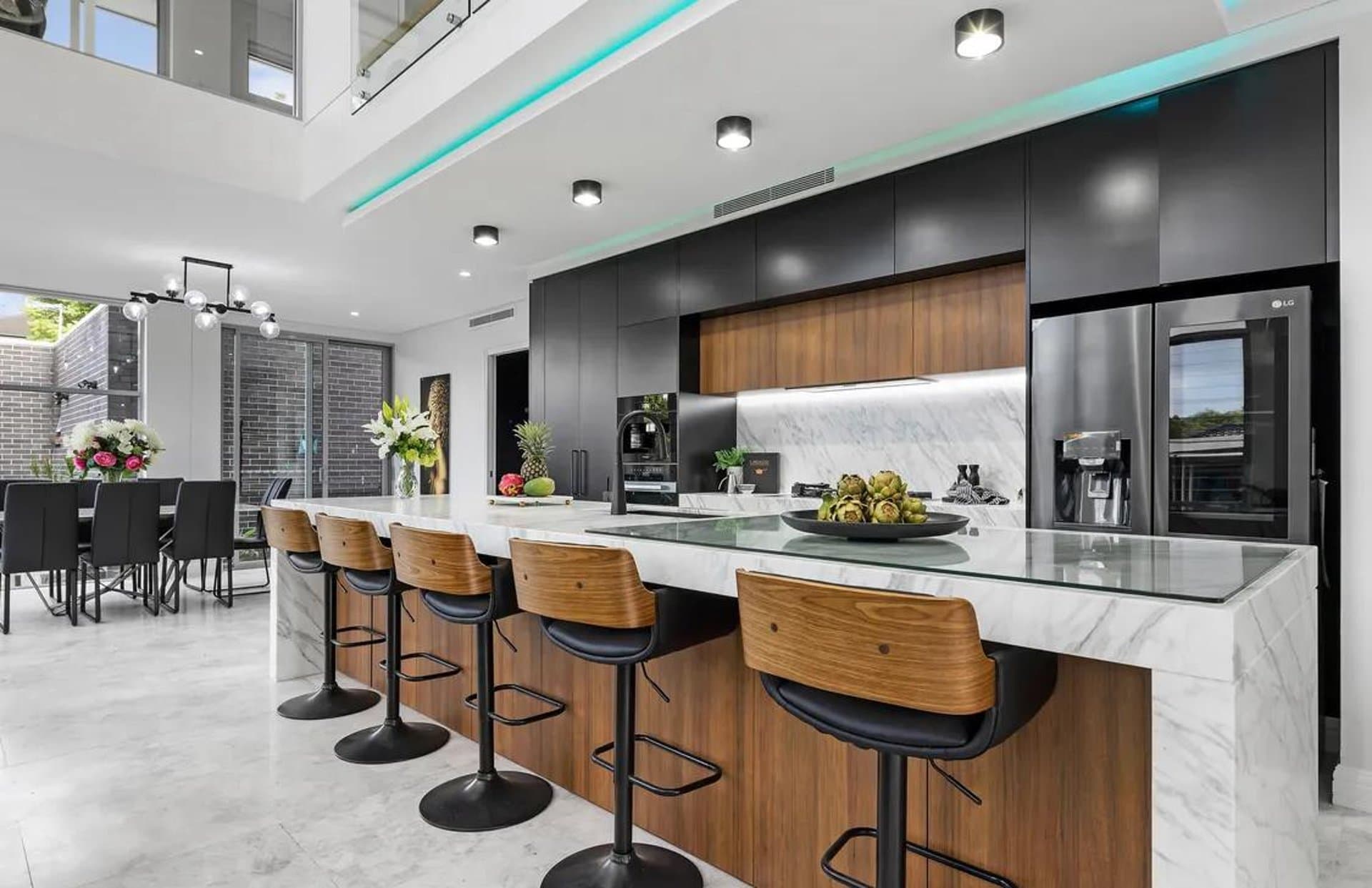 Marble island kitchen in Sydney with walnut joinery and black cabinets