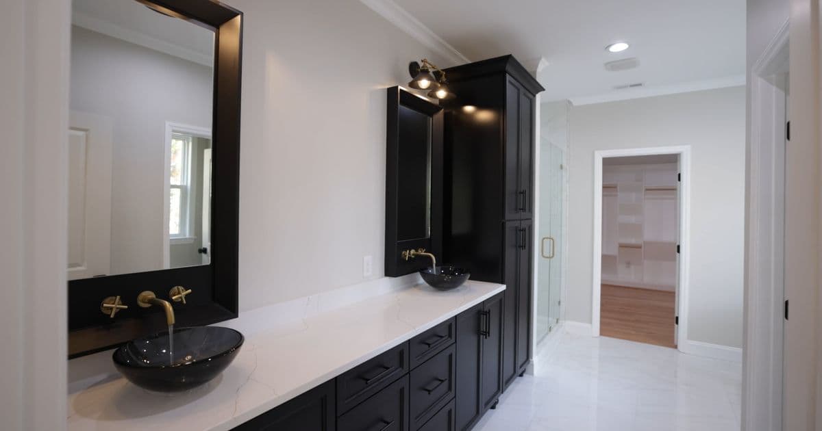 Black joinery laundry vanity with a marble benchtop and brass tapware in Sydney